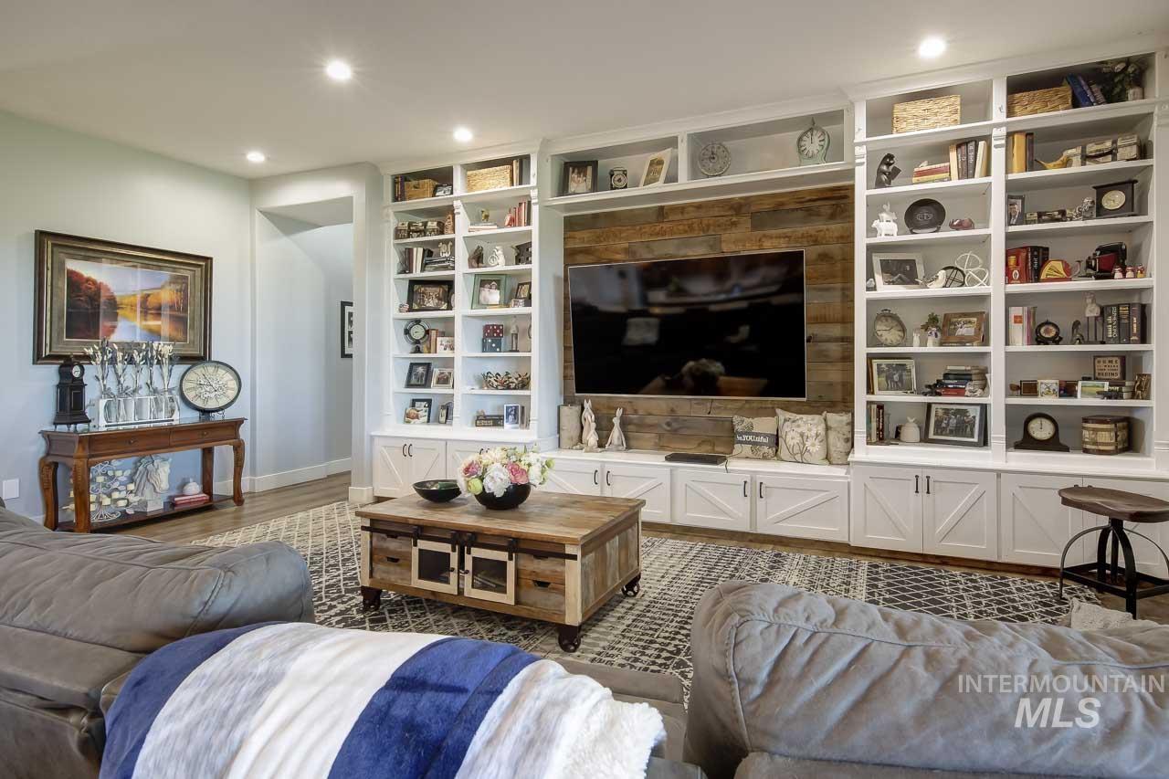 Living area with built in features, recessed lighting, and wood finished floors