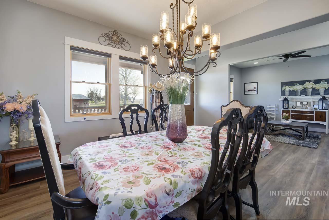 Dining room featuring wood finished floors, ceiling fan, and a chandelier