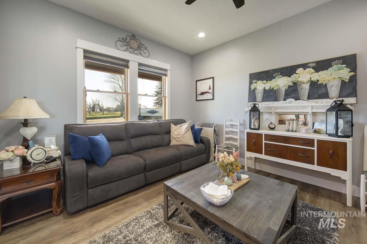 Living area with dark wood-style flooring, recessed lighting, and ceiling fan