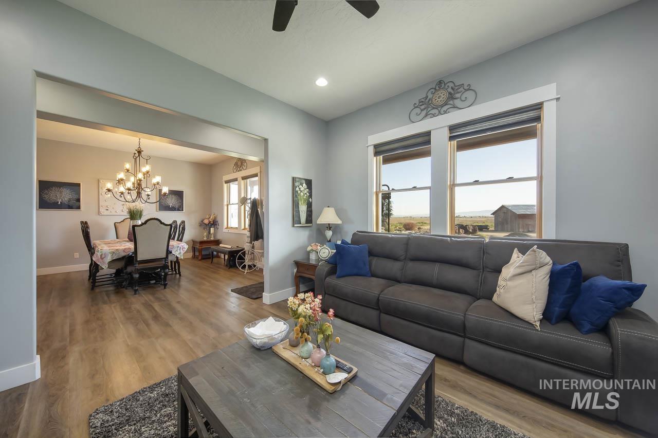 Living area featuring wood finished floors, recessed lighting, a chandelier, and ceiling fan