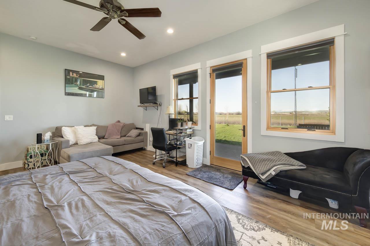 Bedroom with wood finished floors, multiple windows, recessed lighting, a desk, and ceiling fan
