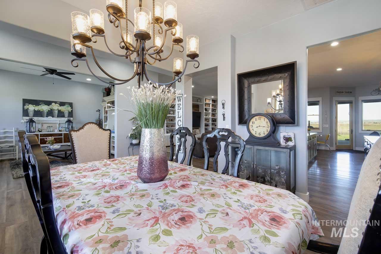 Dining room featuring dark wood-style floors, a ceiling fan, a chandelier, and recessed lighting