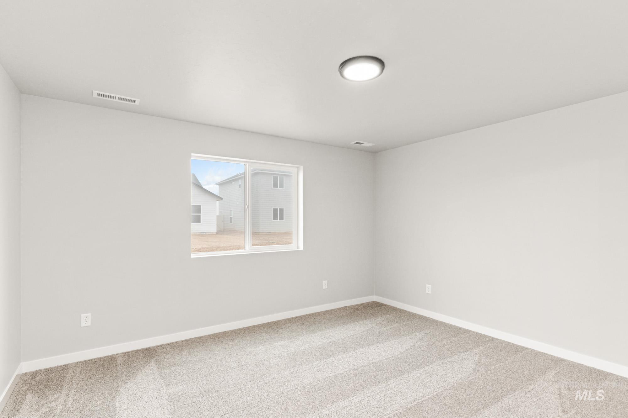 Carpeted spare room with baseboards