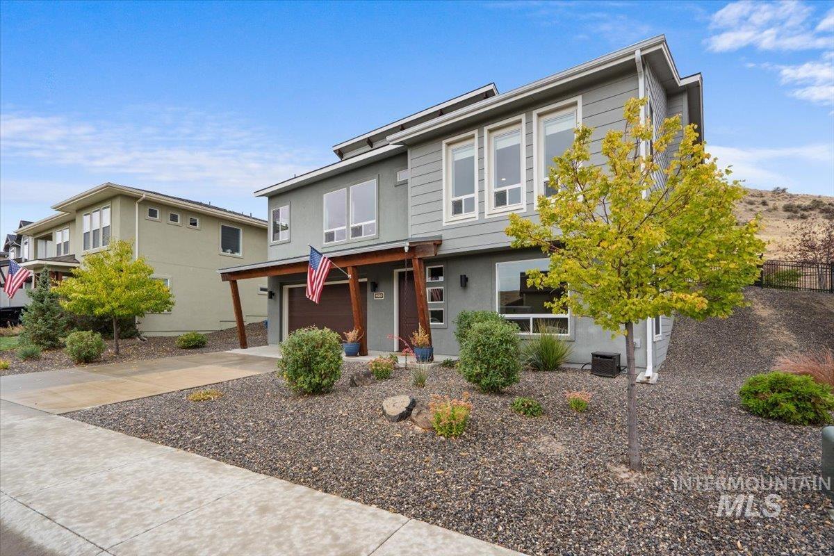 View of front of home with concrete driveway, an attached garage, and stucco siding