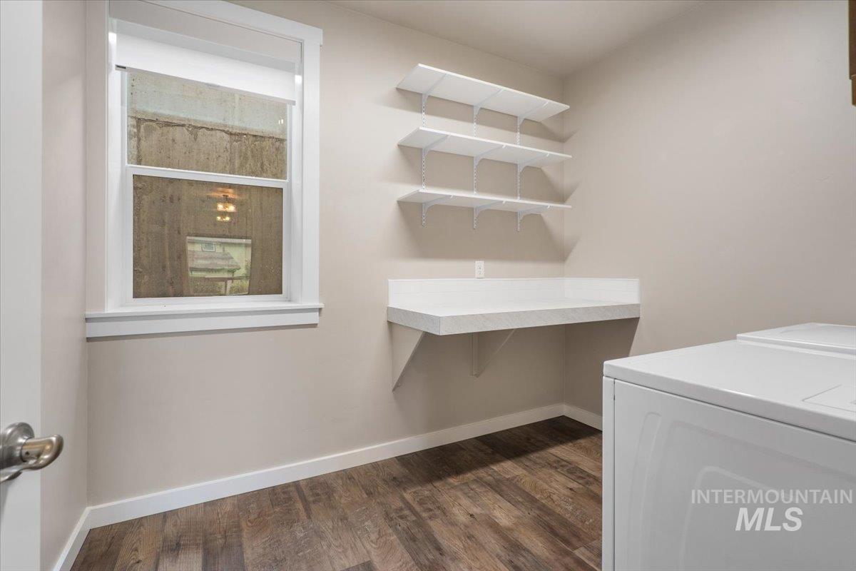 Laundry room with dark wood-style floors and separate washer and dryer