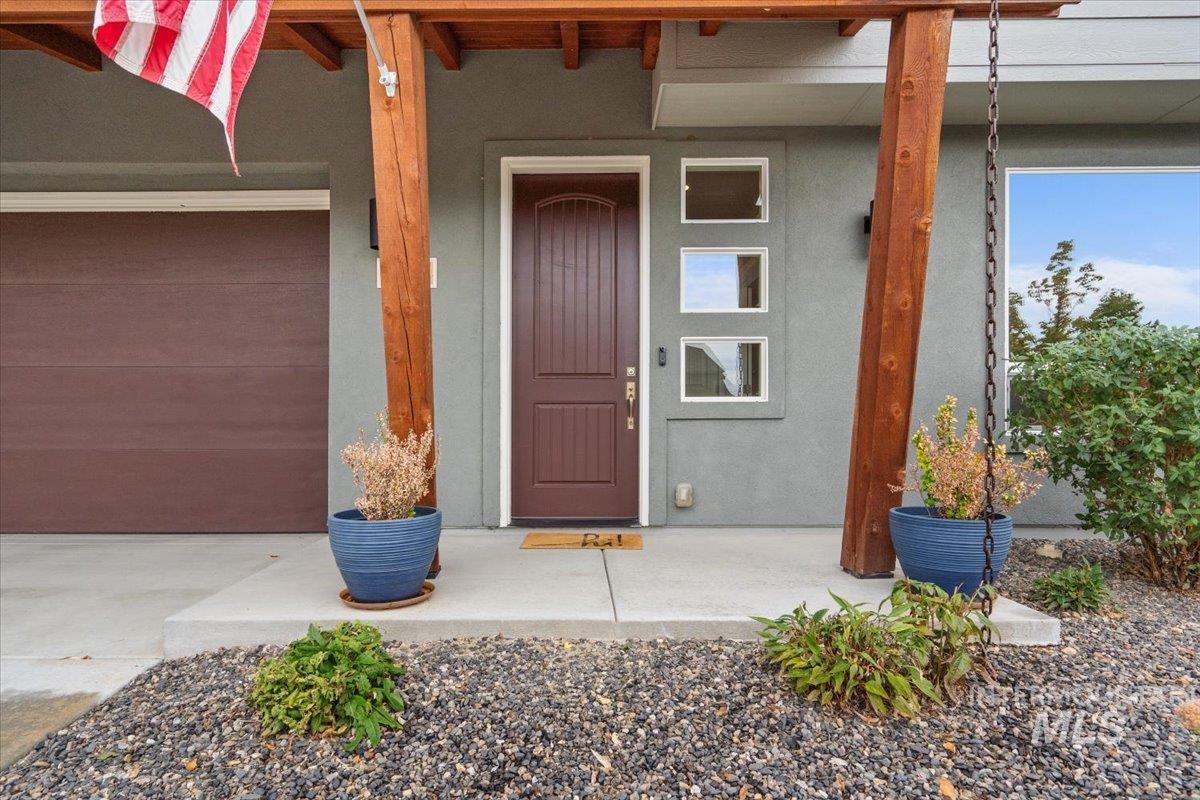 Entrance to property with a porch and stucco siding