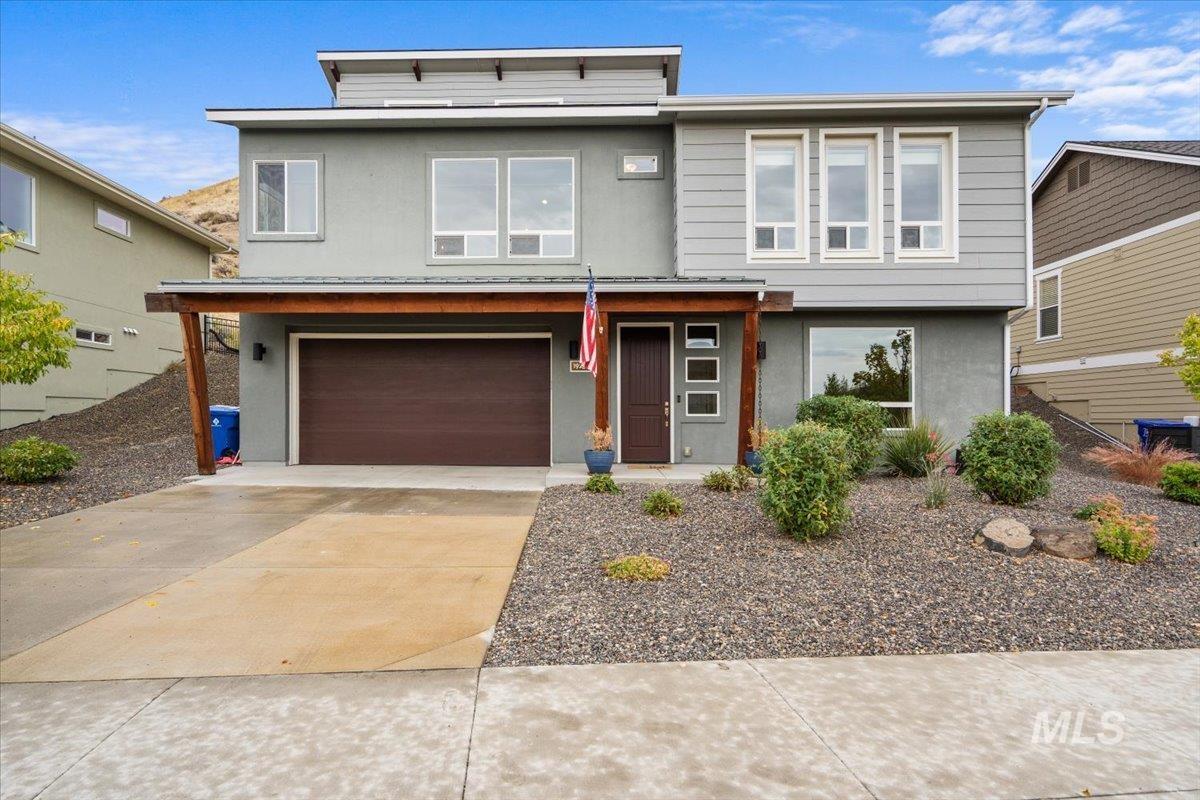 View of front of property with stucco siding, concrete driveway, and an attached garage