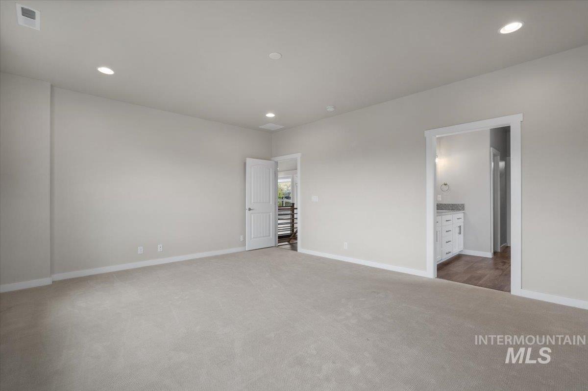 Unfurnished bedroom featuring recessed lighting, light carpet, and ensuite bathroom