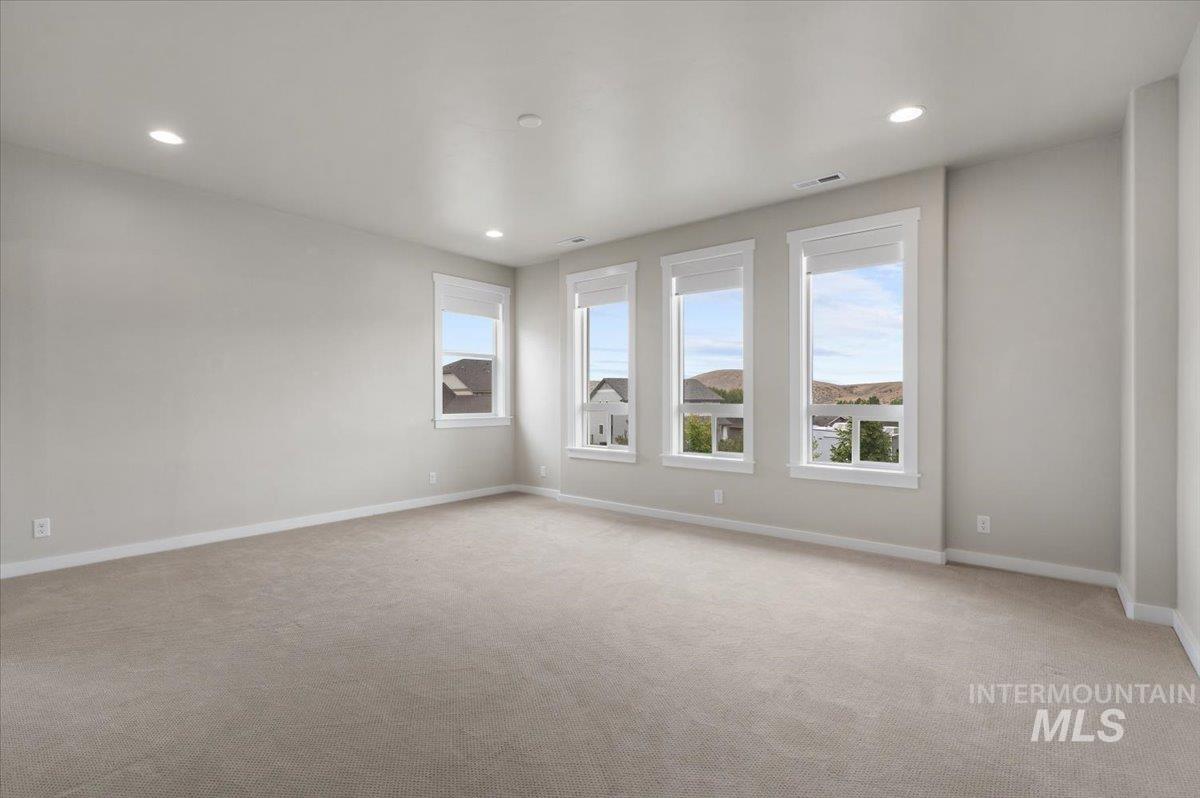 Spare room with plenty of natural light, light colored carpet, and recessed lighting