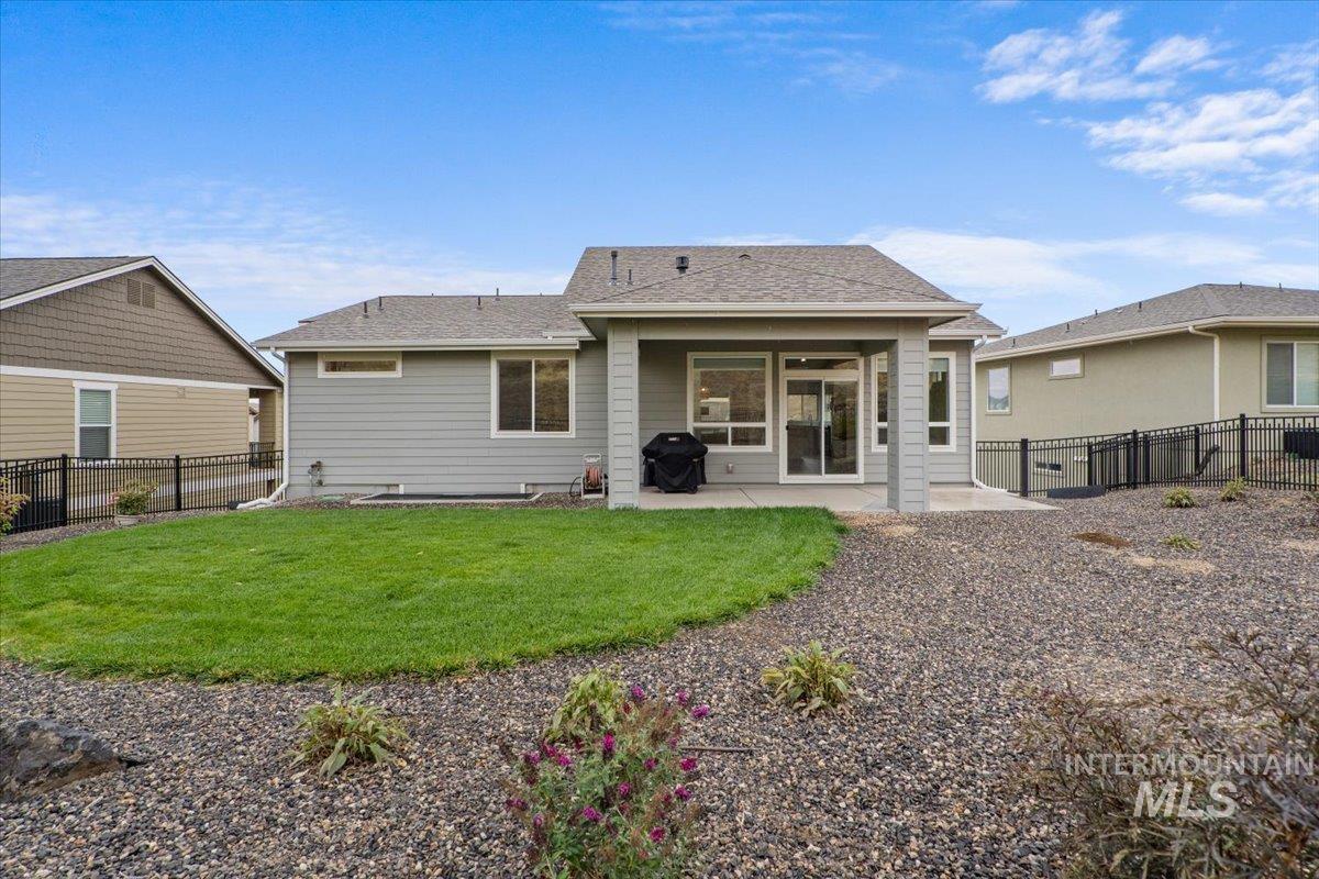 Back of house with a fenced backyard, a patio, and roof with shingles