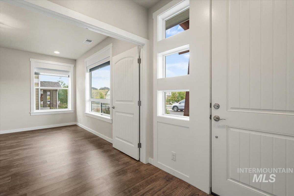 Doorway to outside featuring baseboards and wood finished floors