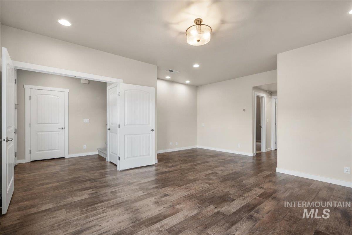 Unfurnished room with recessed lighting and dark wood-type flooring