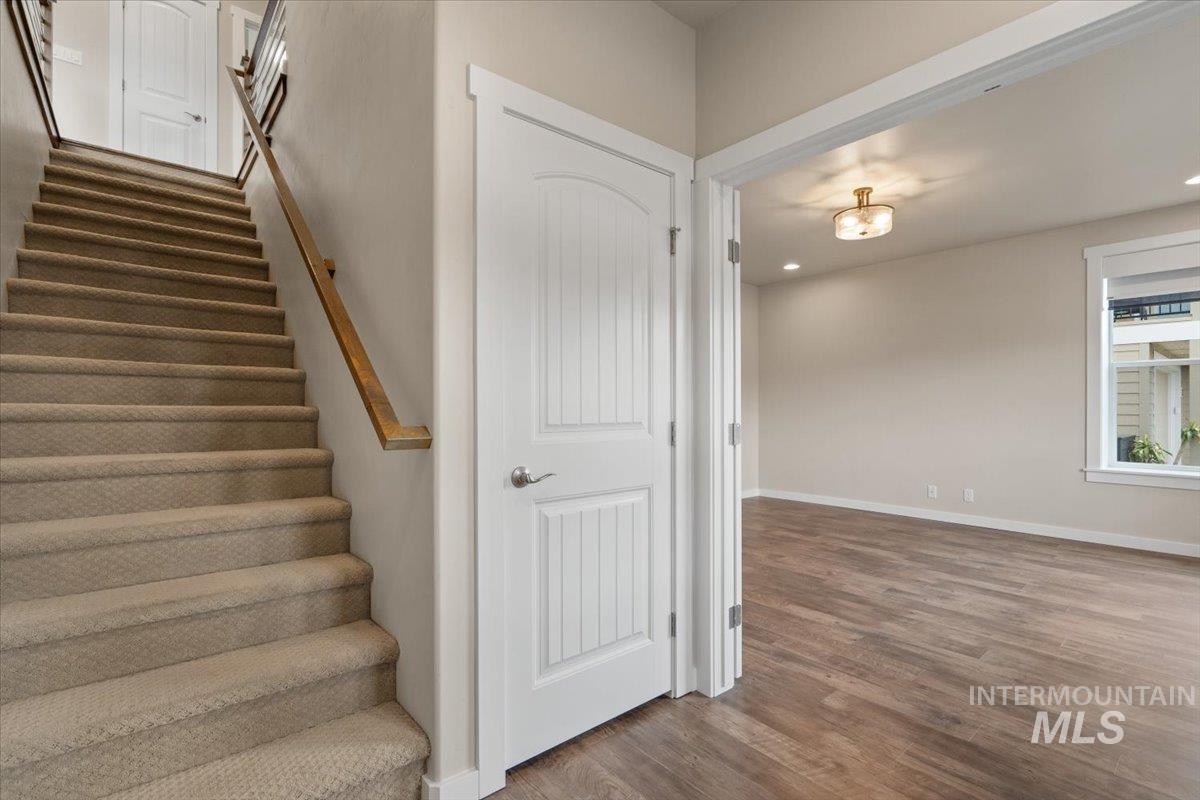 Staircase with wood finished floors and recessed lighting