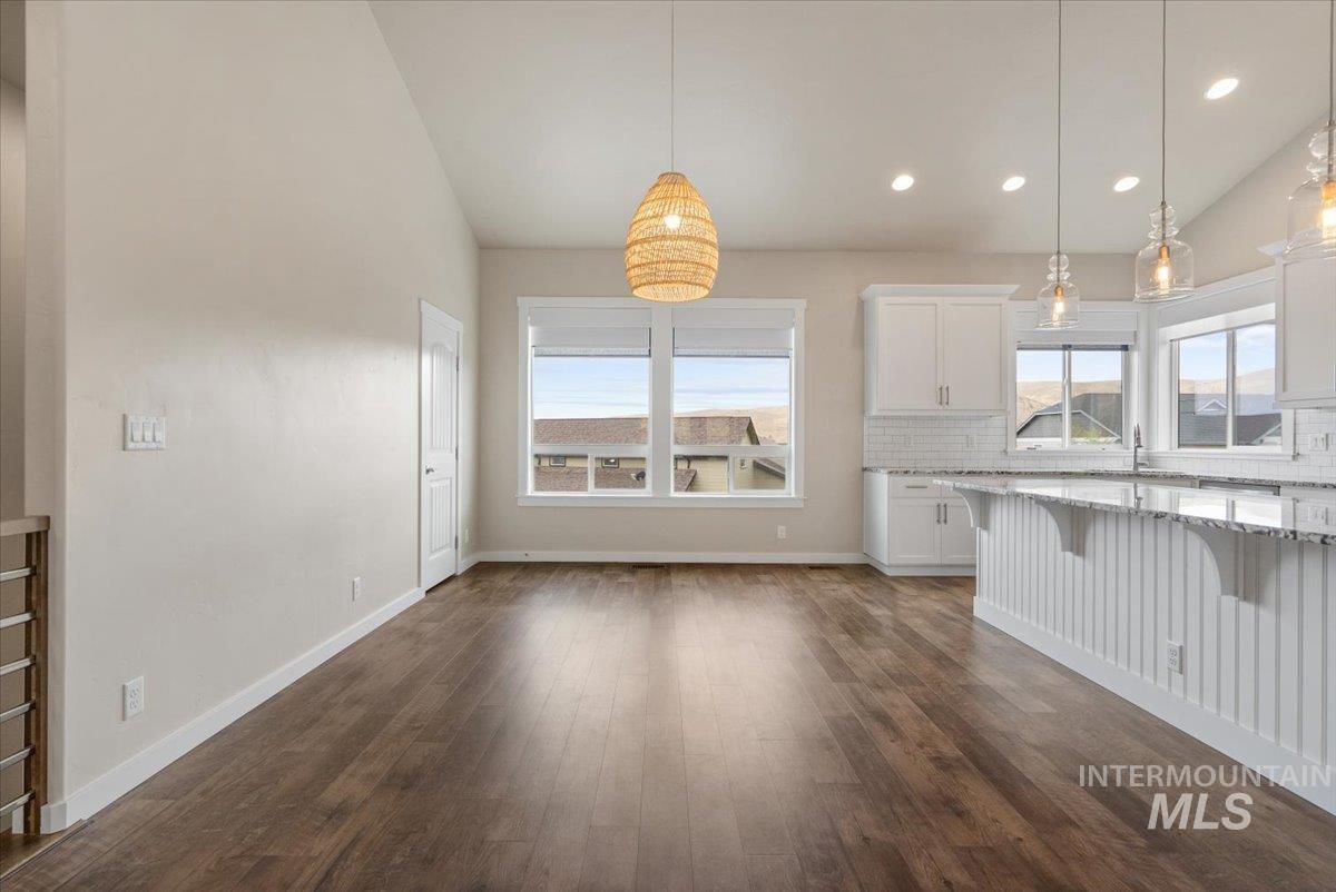 Unfurnished living room with lofted ceiling, dark wood finished floors, and recessed lighting