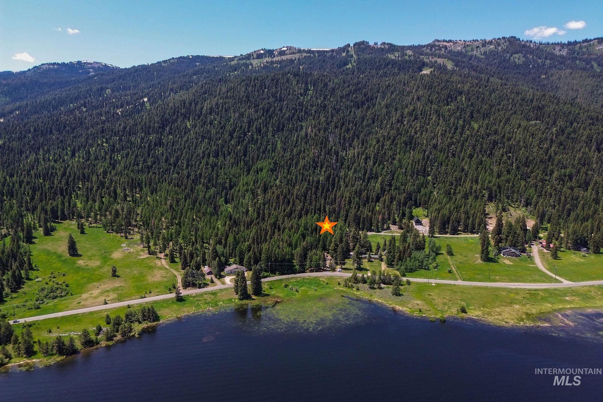 Aerial view of property and surrounding area with a heavily wooded area and a water and mountain view