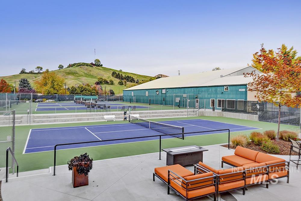 View of tennis court with community basketball court, an outdoor living space, and a patio
