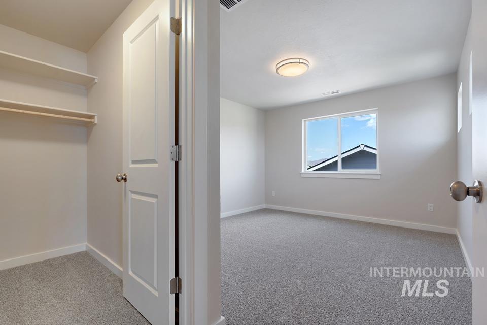 Unfurnished bedroom with carpet floors and baseboards