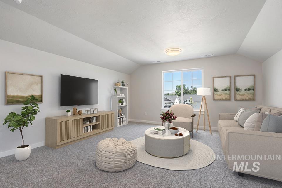Carpeted living area with lofted ceiling