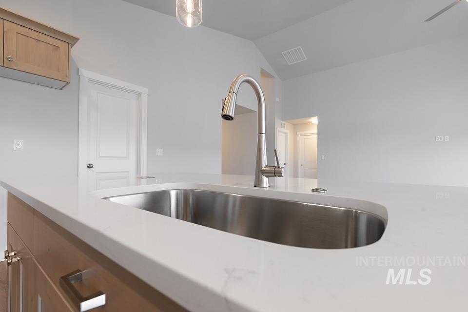 Kitchen view of light countertops and brown cabinets