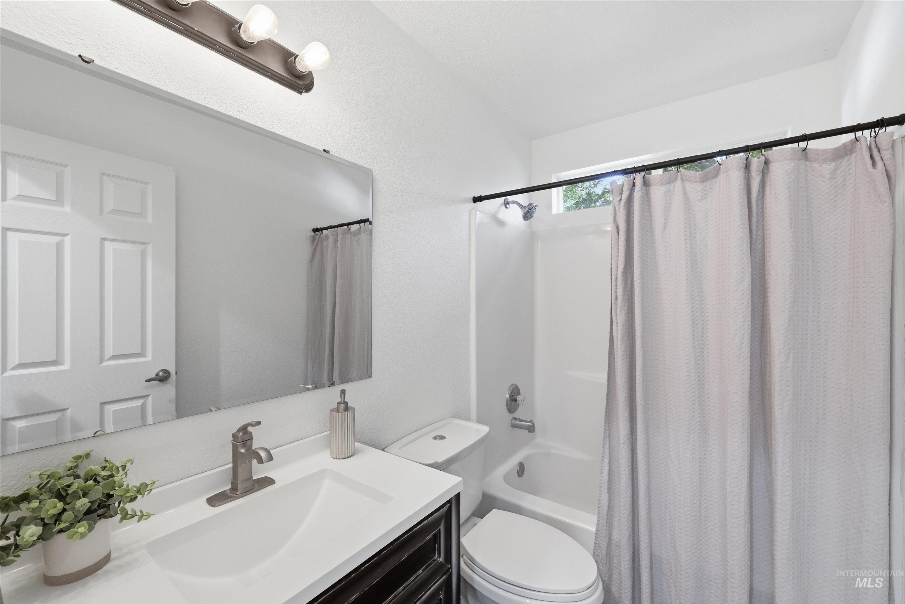 Bathroom featuring a vanity with a white integrated sink, brushed nickel faucet, and dark wood-finish cabinetry