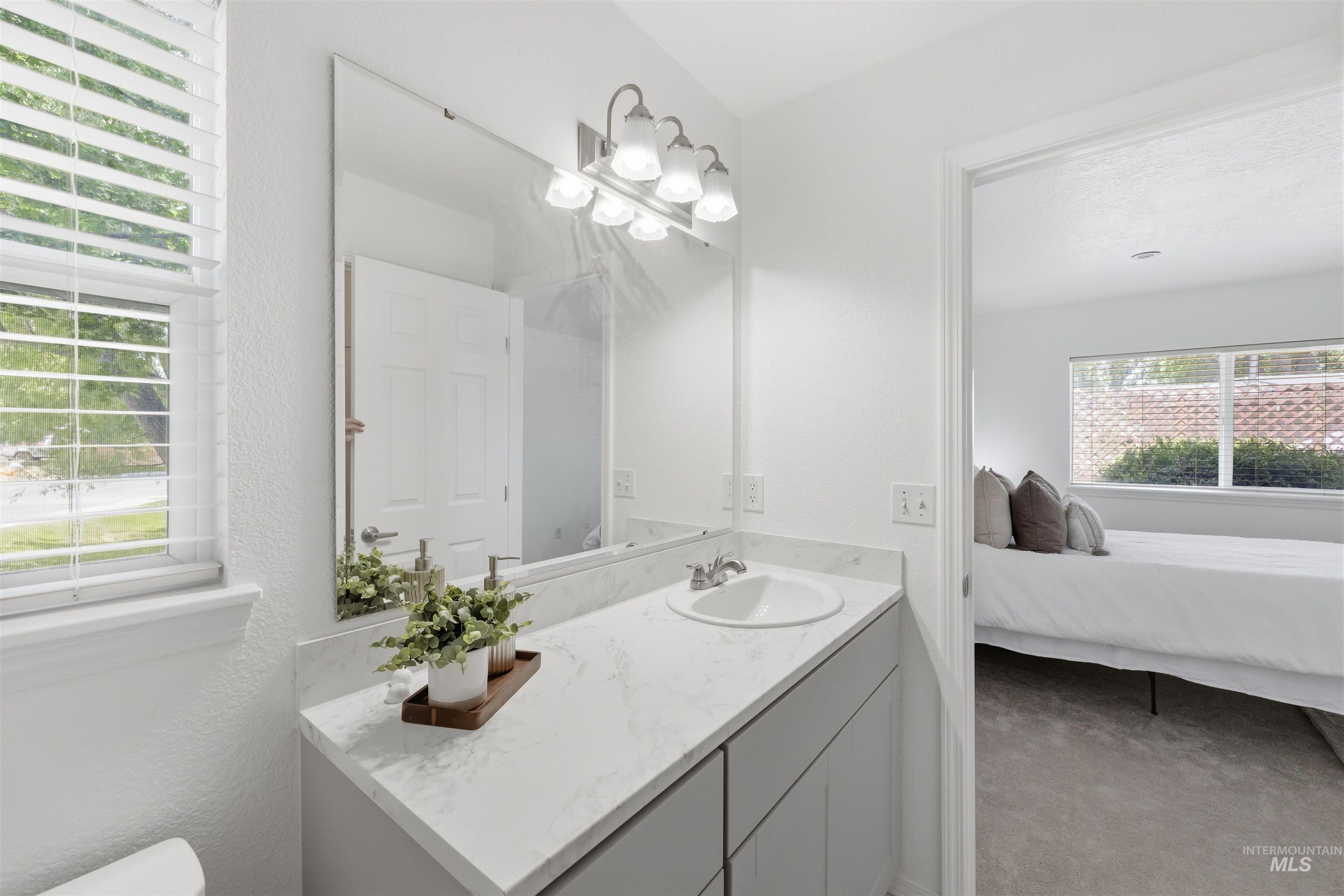 Bathroom vanity featuring a rectangular under-mount sink, speckled countertop, and modern gray cabinetry