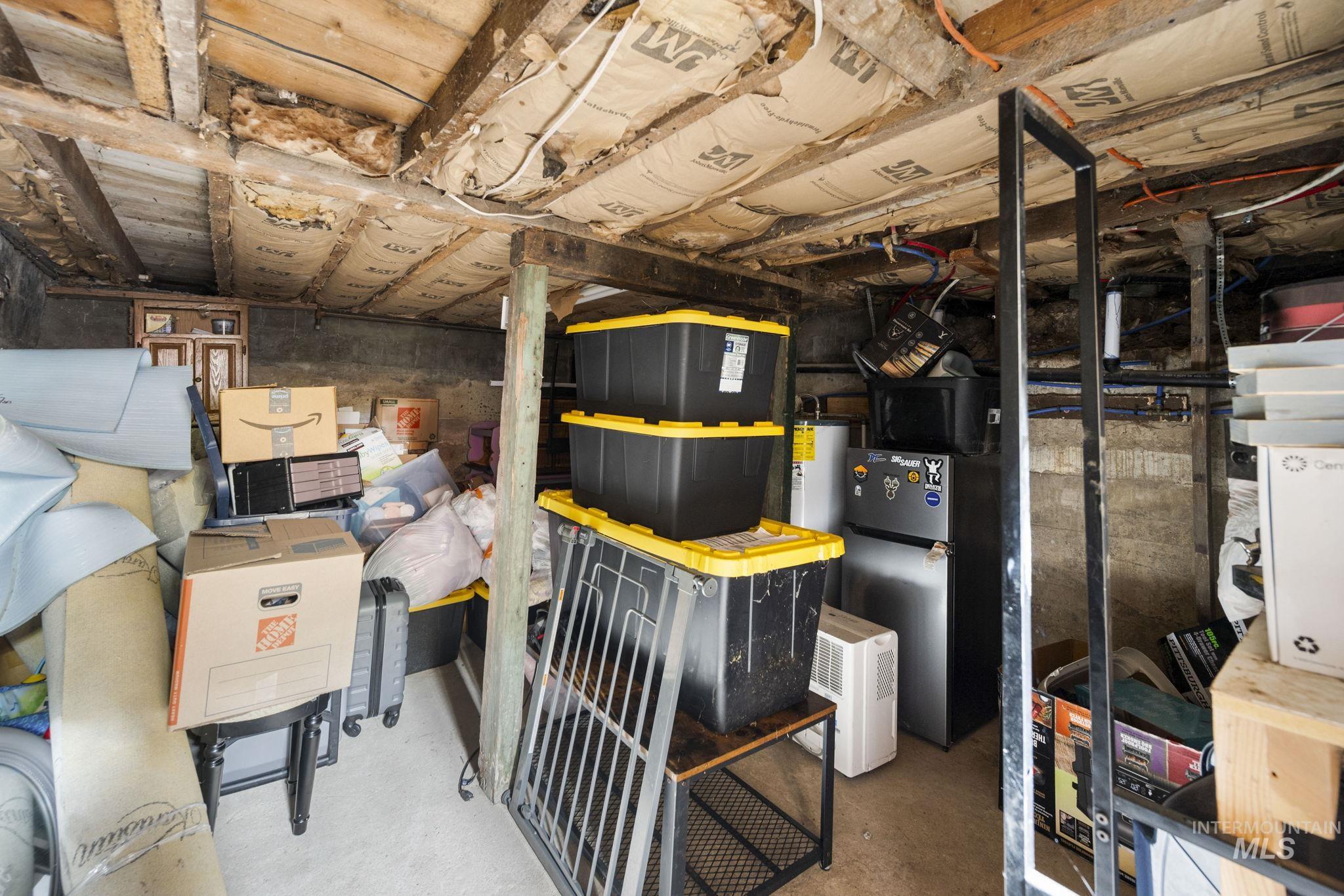 Unfinished basement featuring freestanding refrigerator