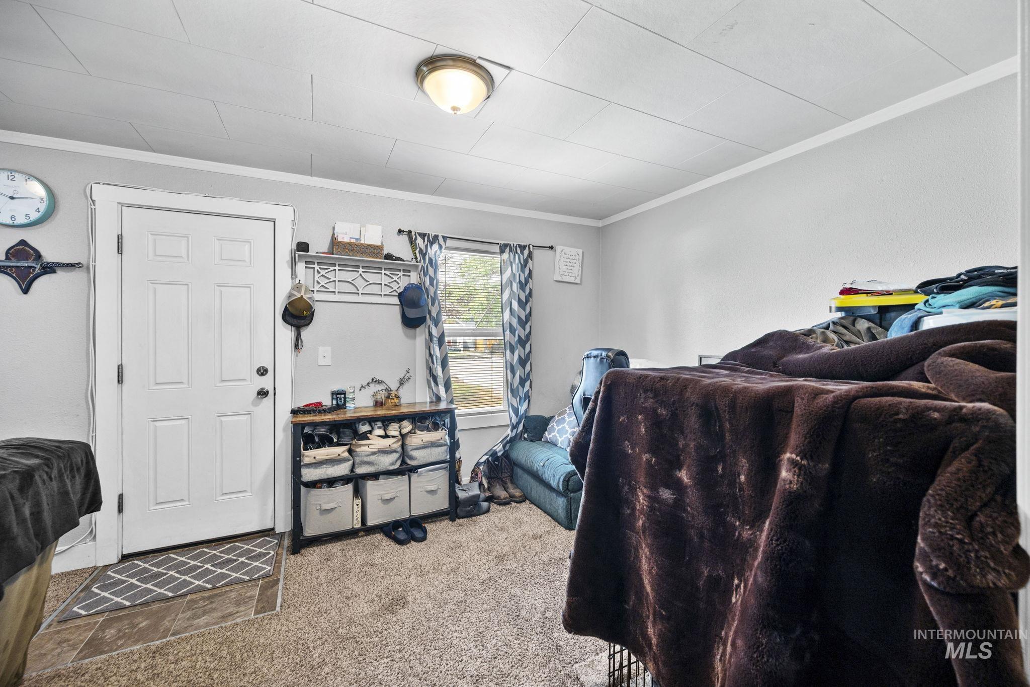 Carpeted bedroom with ornamental molding