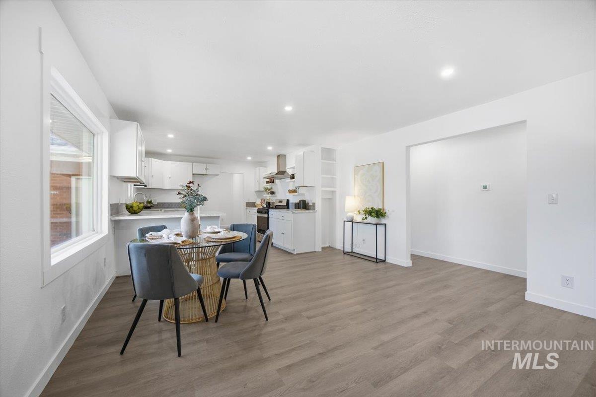 Dining room with light wood-style floors and recessed lighting