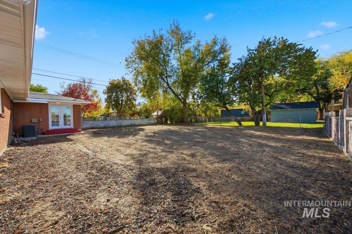 Fenced backyard featuring french doors