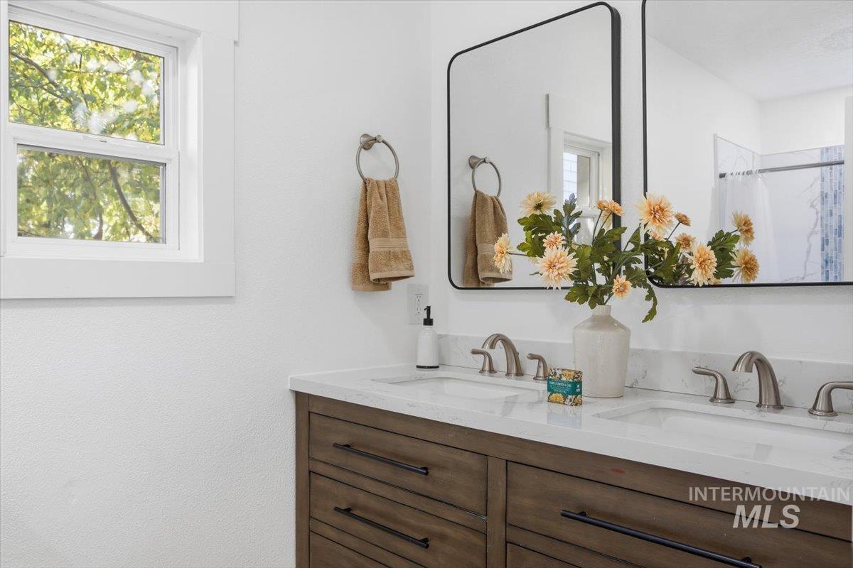 Bathroom featuring double vanity and a shower with shower curtain