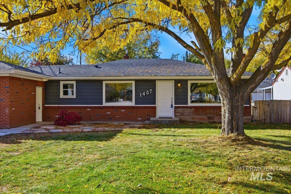 Ranch-style house featuring a chimney and brick siding