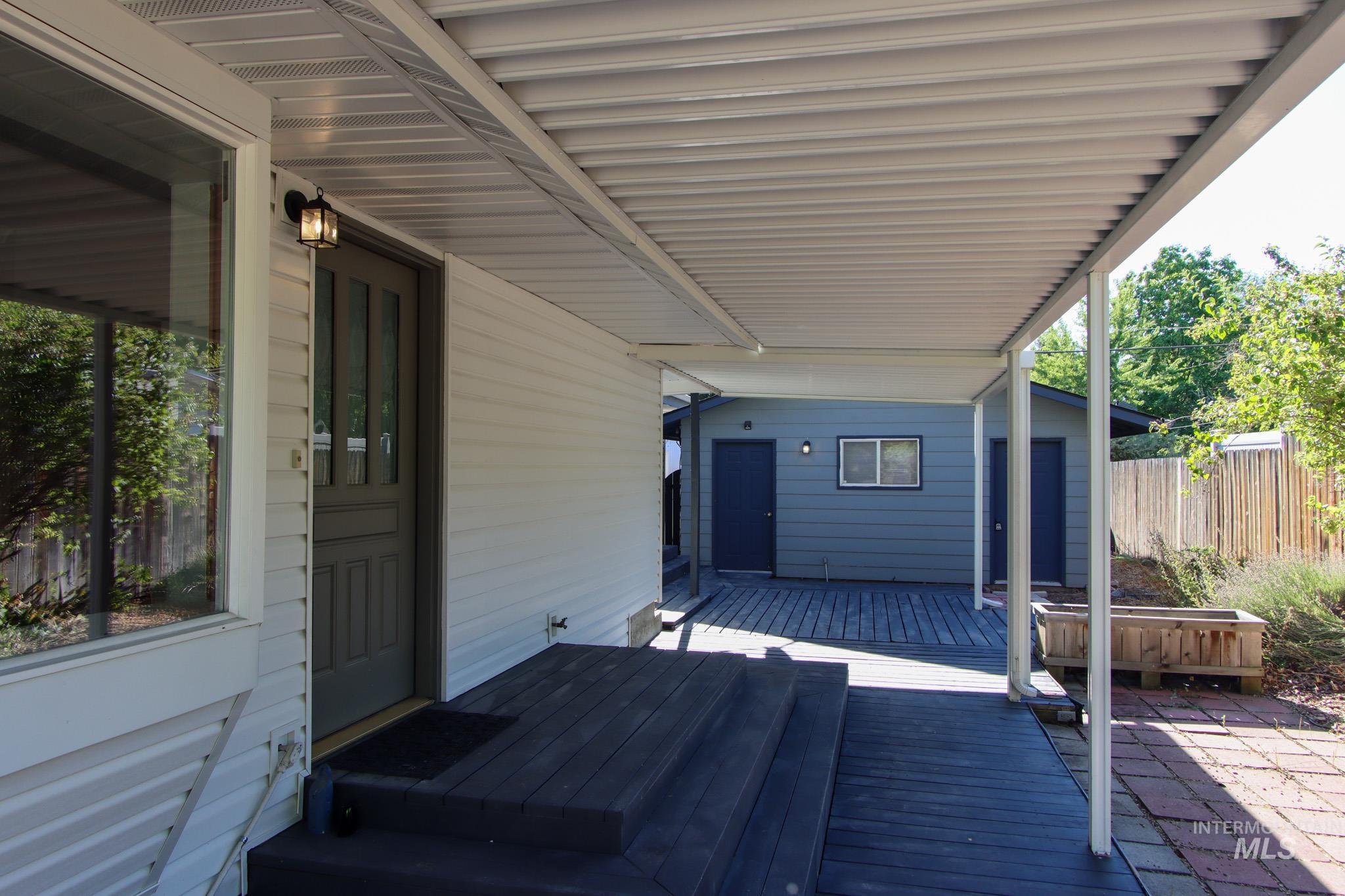 View of patio with a hot tub and a deck