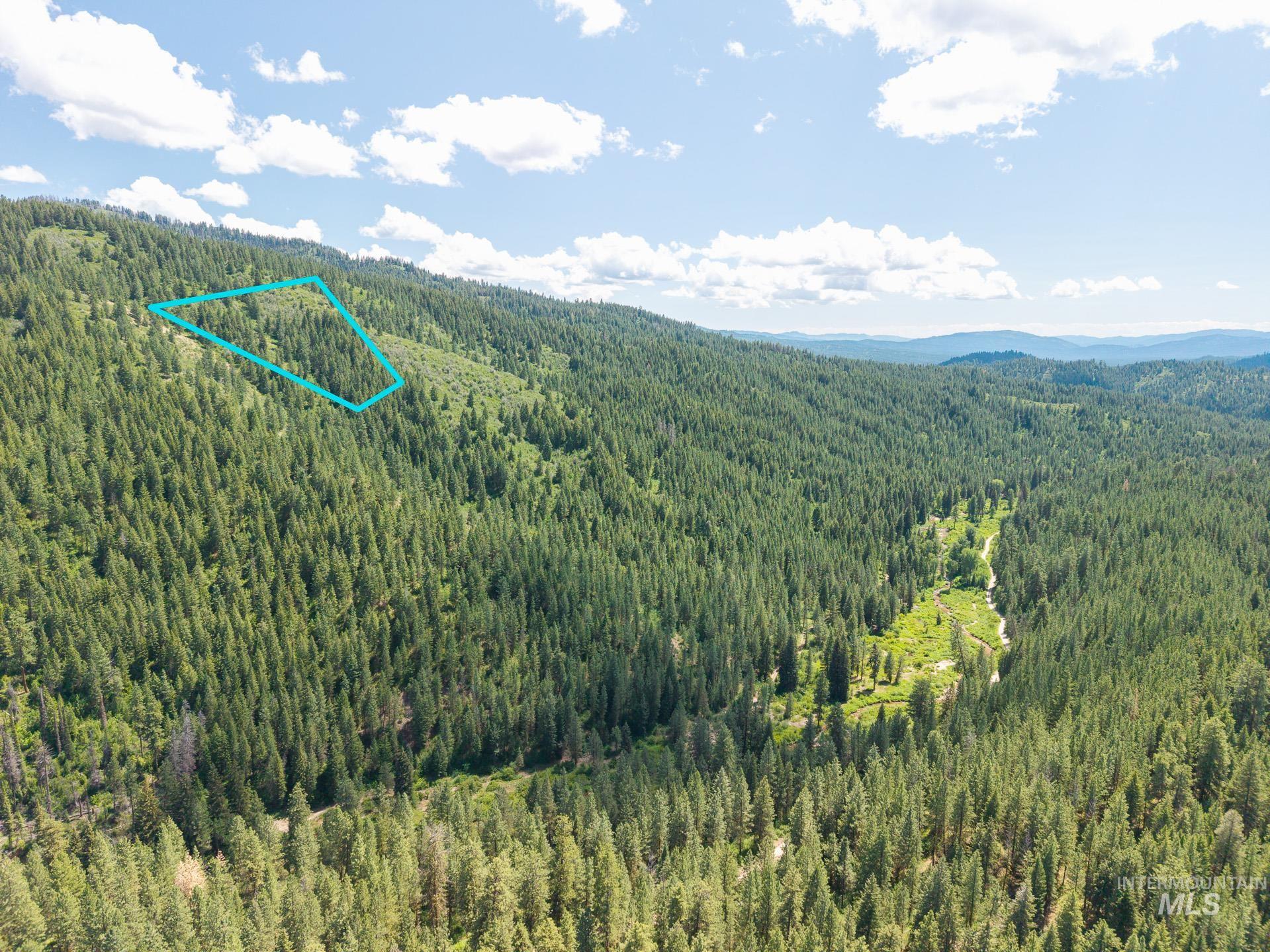 Aerial view of property's location featuring property parcel outlined and a mountainous background