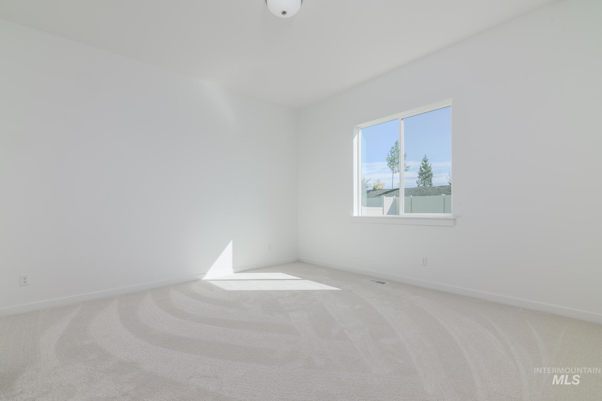 Carpeted empty room featuring baseboards