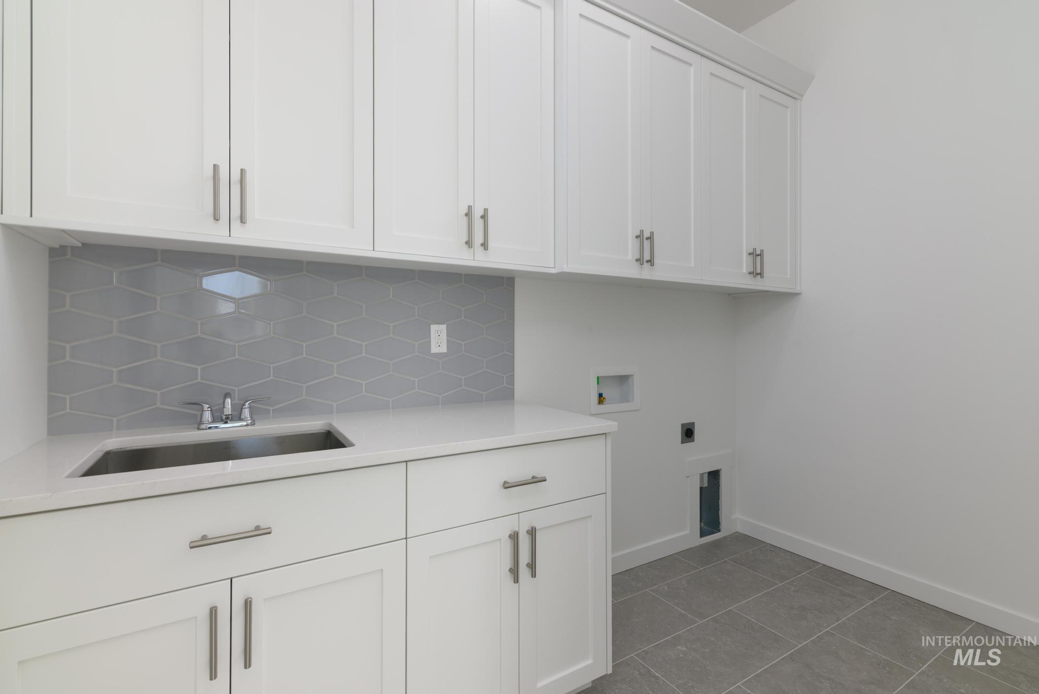 Laundry room with light tile patterned floors, cabinet space, washer hookup, and electric dryer hookup
