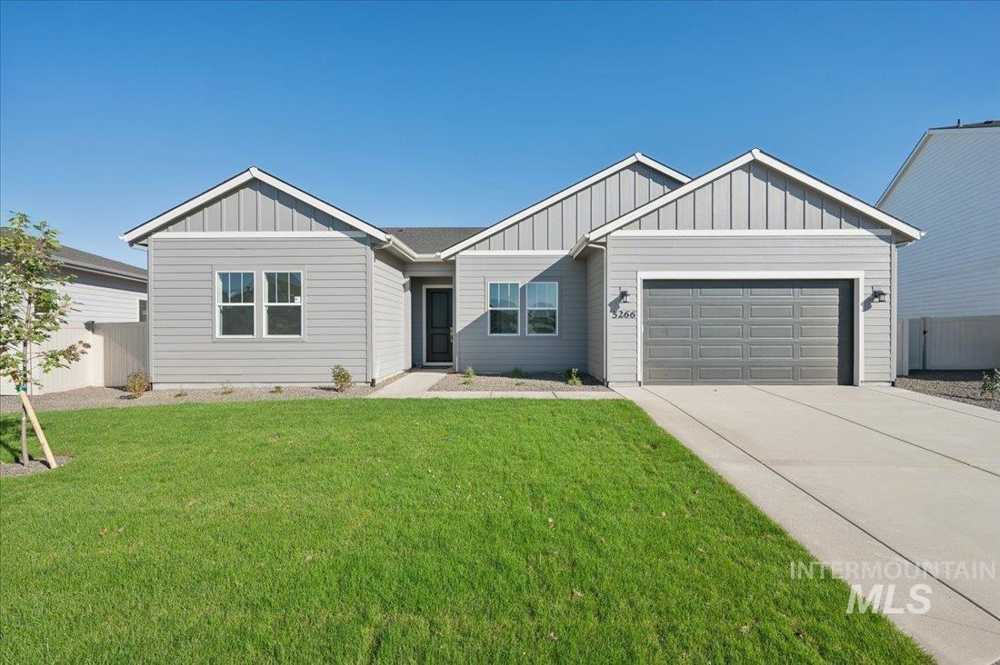 View of front of home featuring board and batten siding, an attached garage, and driveway