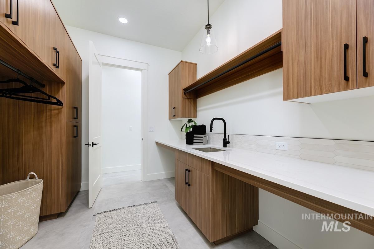 Laundry room featuring concrete flooring and recessed lighting