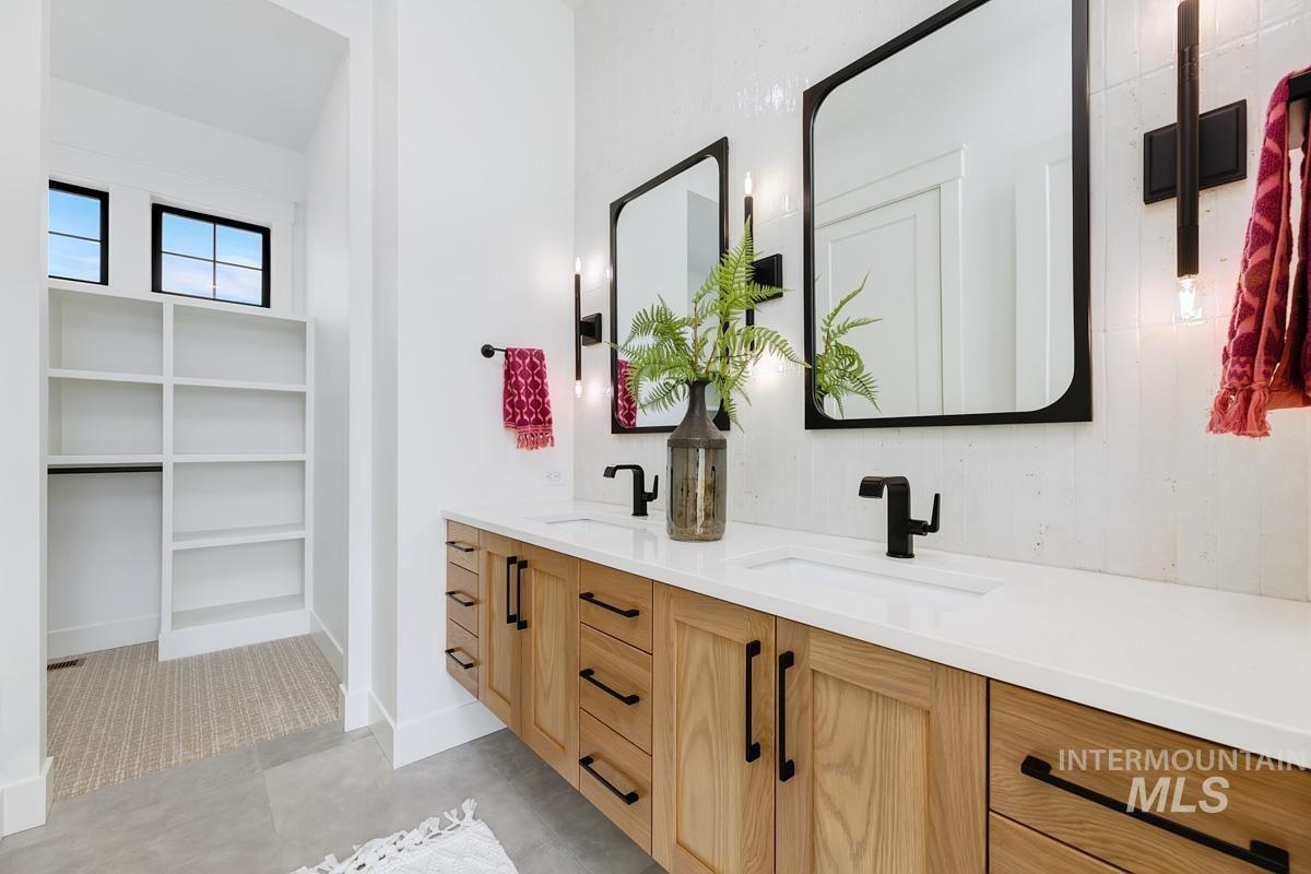 Bathroom with double vanity and a spacious closet