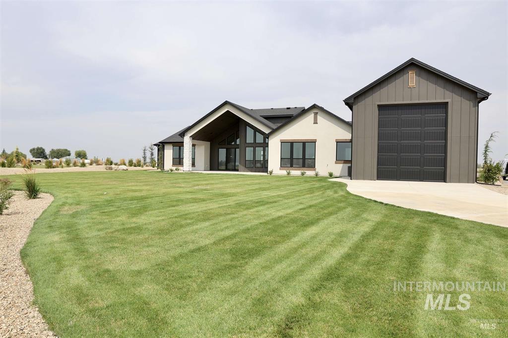 View of front of house featuring a front lawn, driveway, and board and batten siding