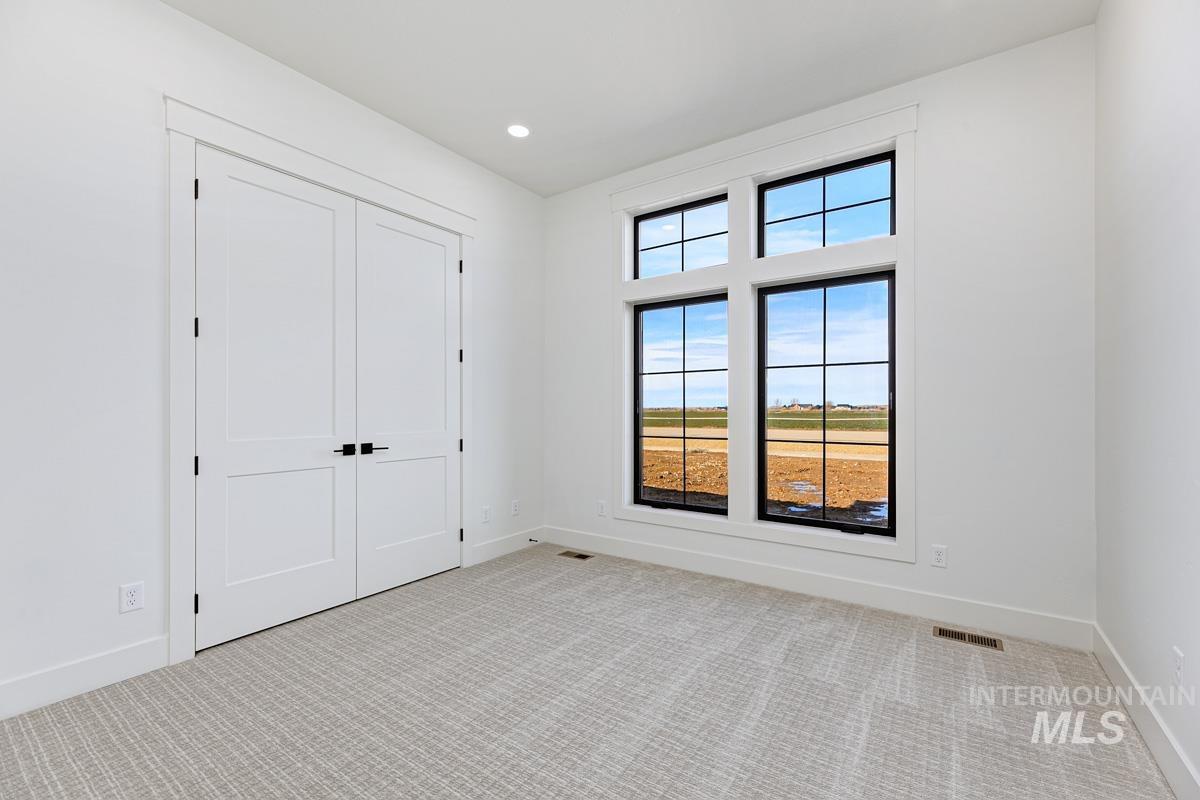 Unfurnished bedroom with light colored carpet, a closet, and recessed lighting
