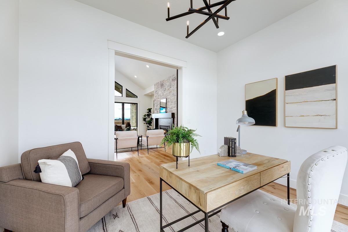 Home office with wood finished floors, high vaulted ceiling, a chandelier, recessed lighting, and a fireplace