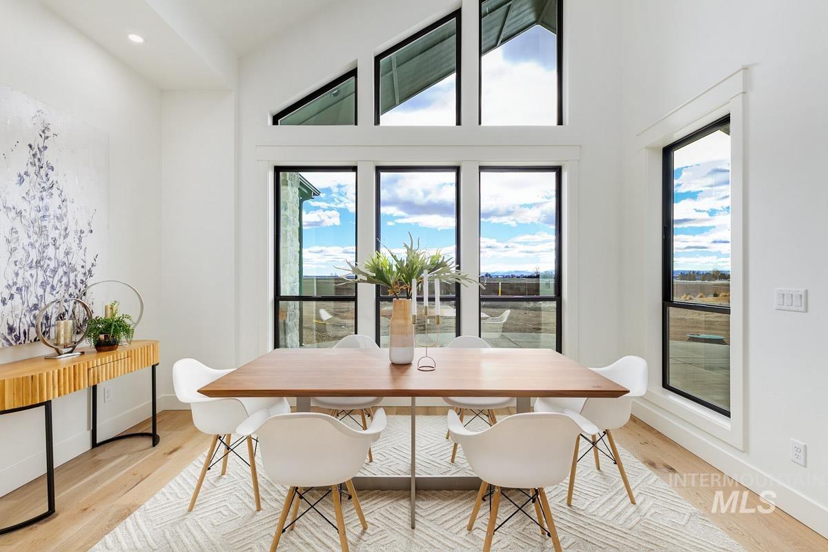 Dining space featuring light wood finished floors, a high ceiling, and recessed lighting