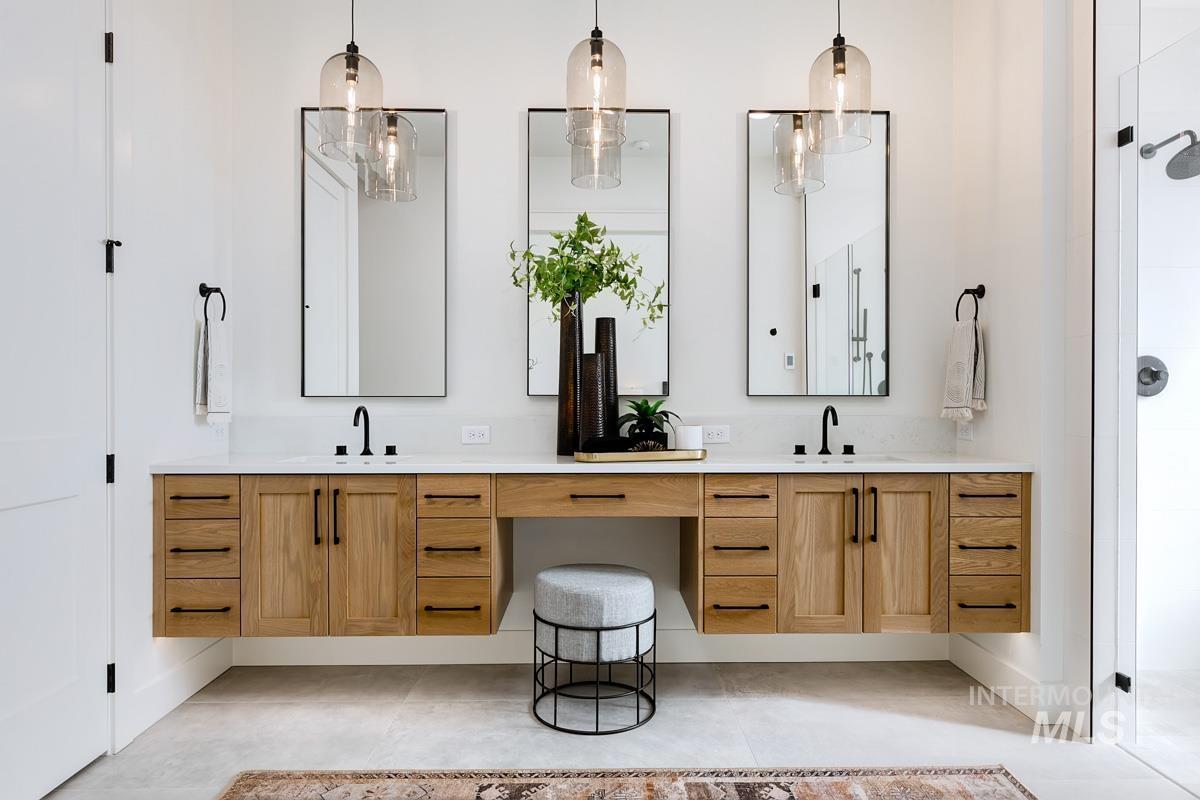 Bathroom with vanity, tiled shower, and light tile patterned flooring