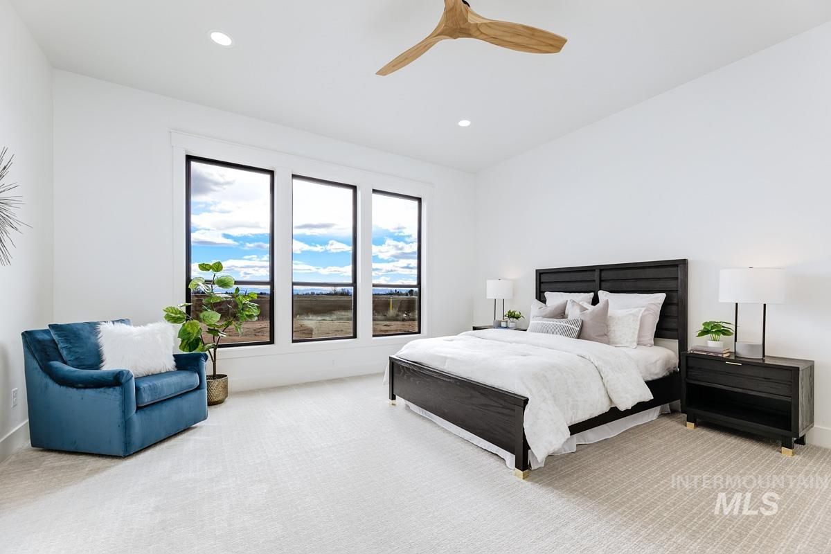Bedroom with light colored carpet, ceiling fan, recessed lighting, and lofted ceiling