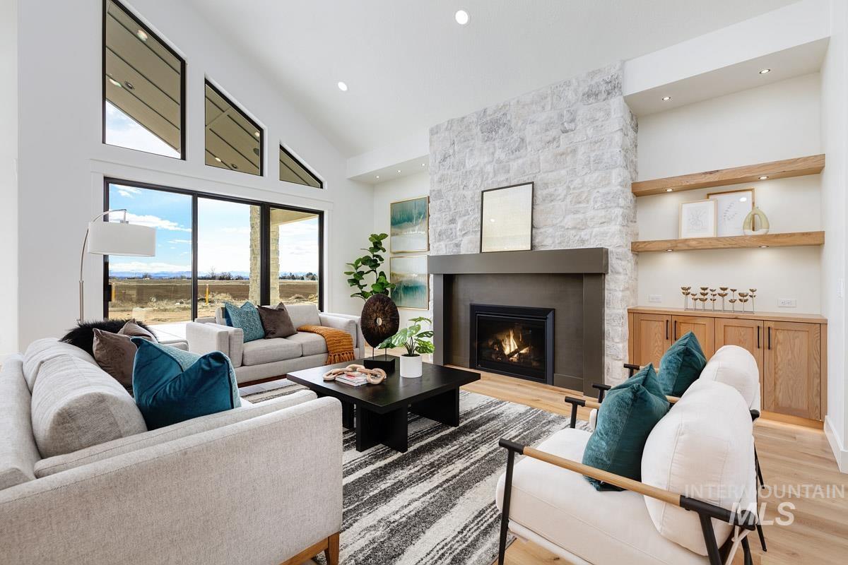 Living room featuring a fireplace, high vaulted ceiling, and light wood-style floors