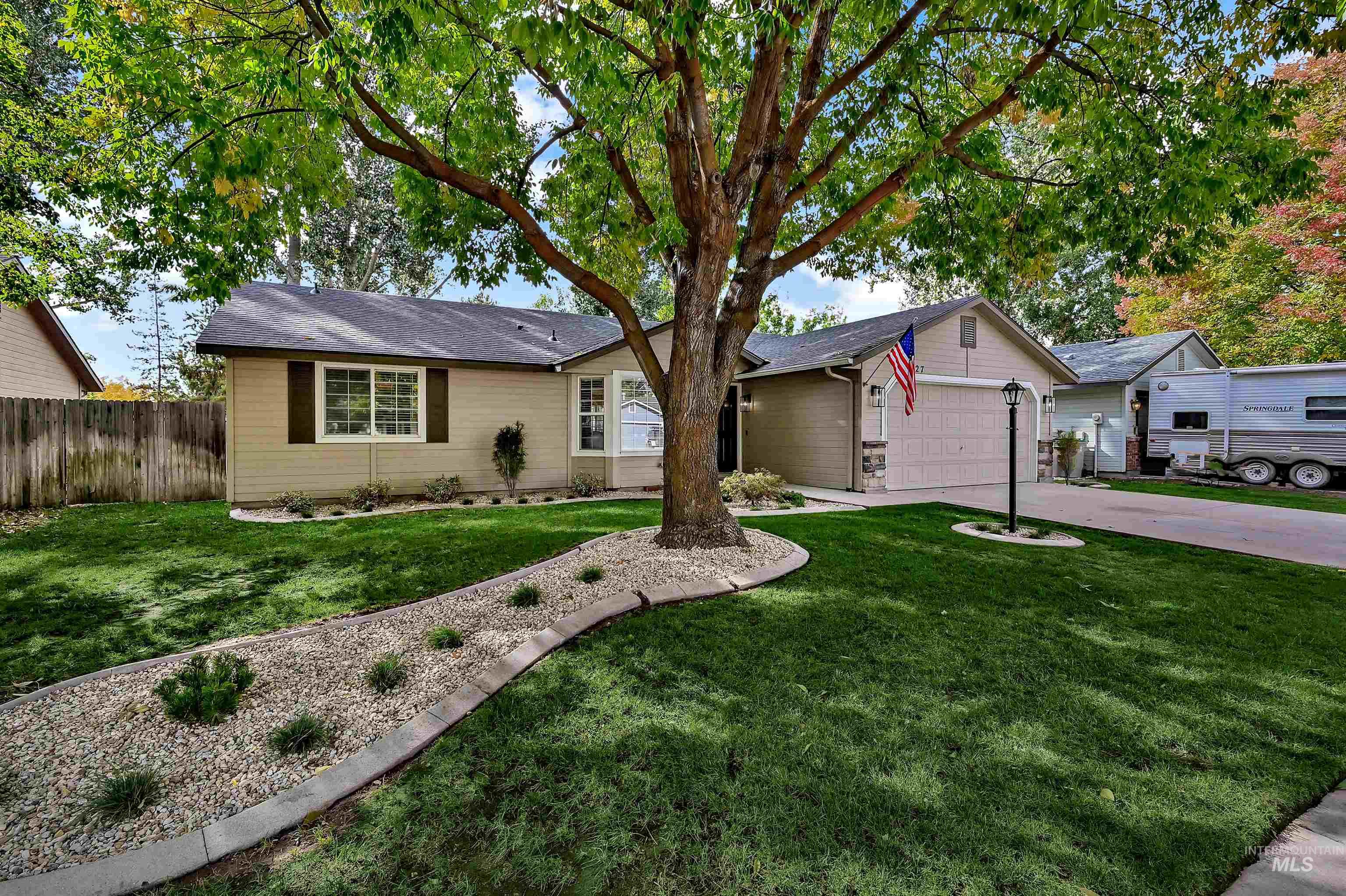 Ranch-style house featuring new and mature landscaping, an attached garage, and a brand new roof
