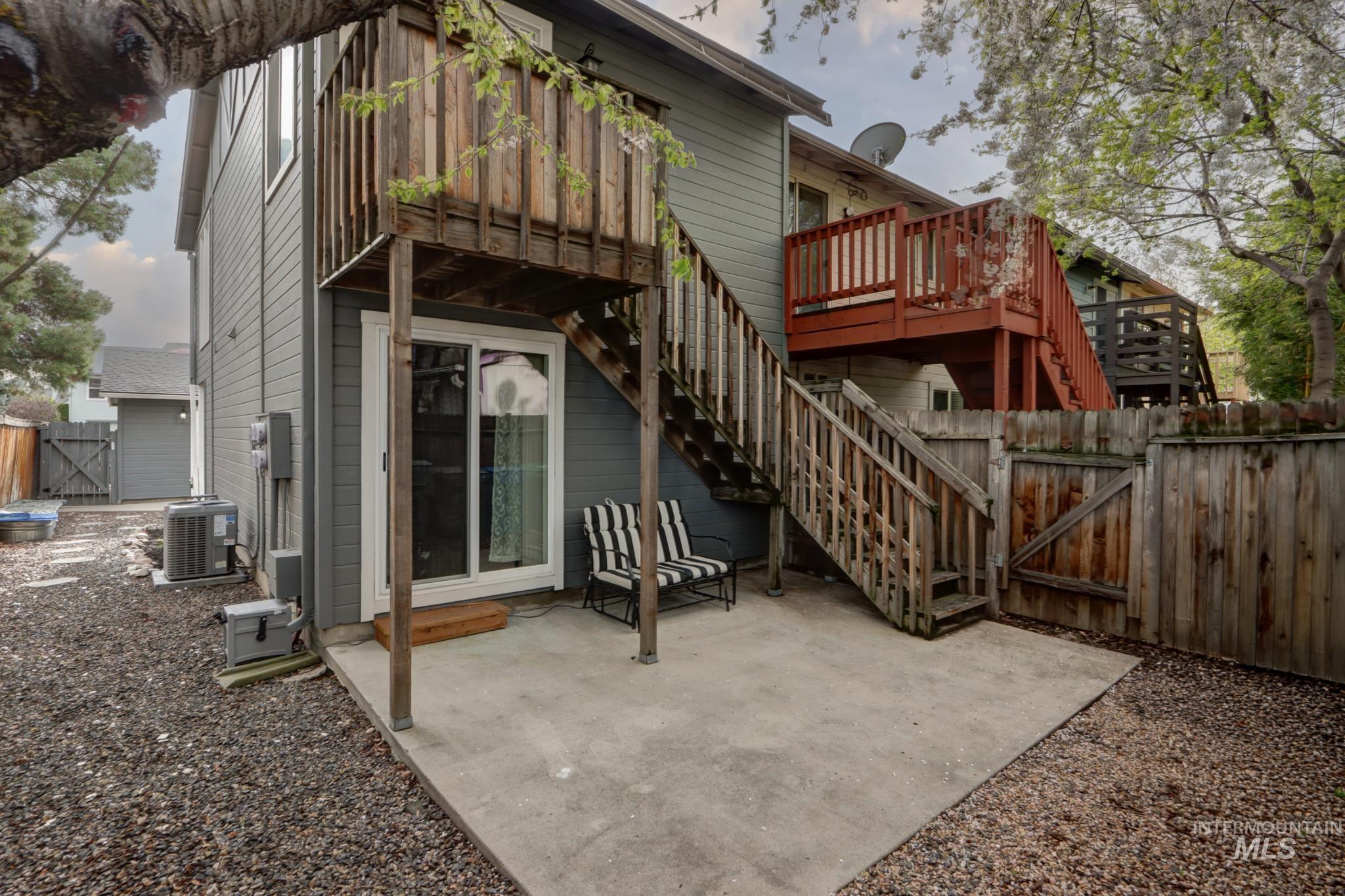 Back of property with a gate, a patio area, a fenced backyard, and a deck
