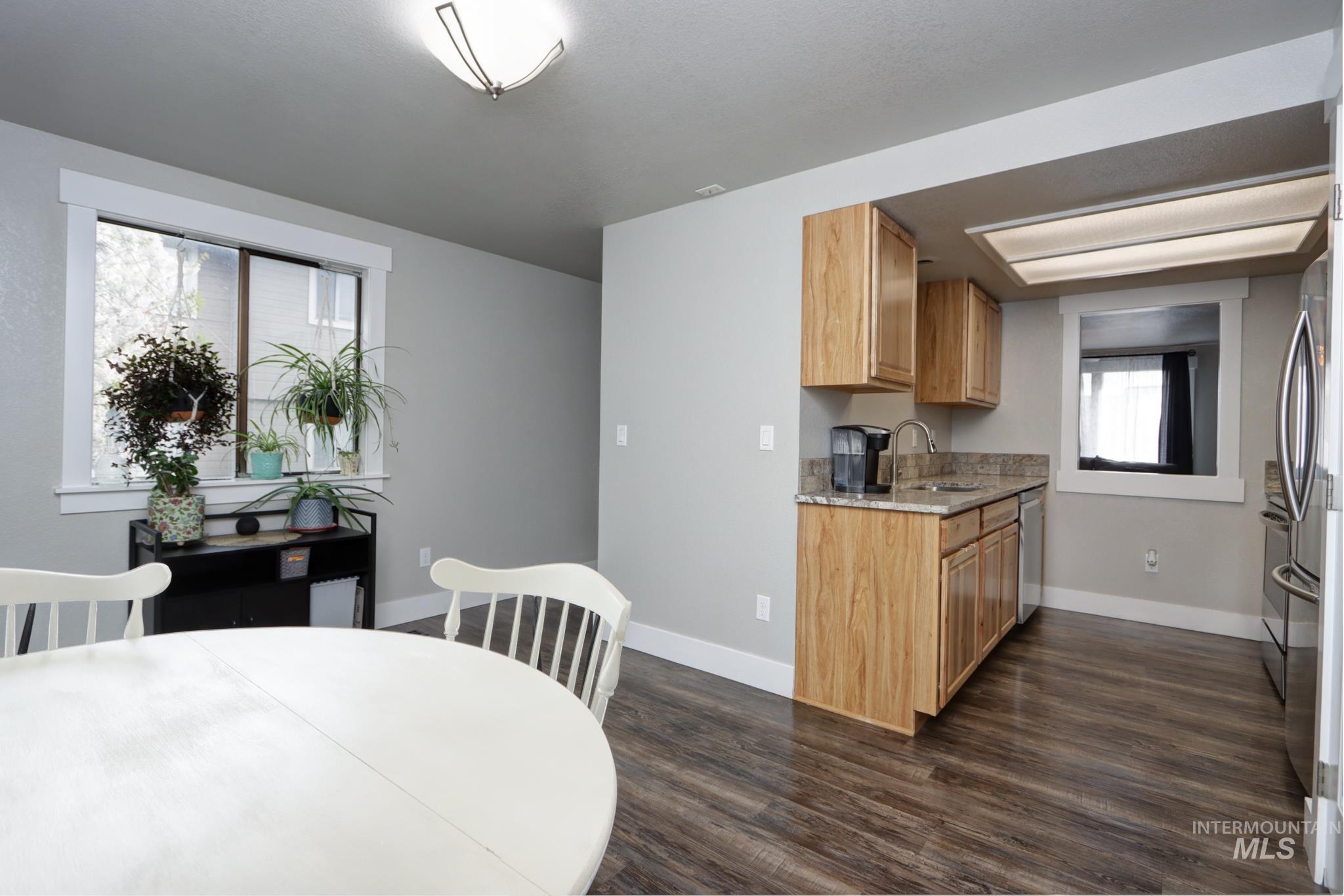 Dining room with dark wood-style flooring and baseboards