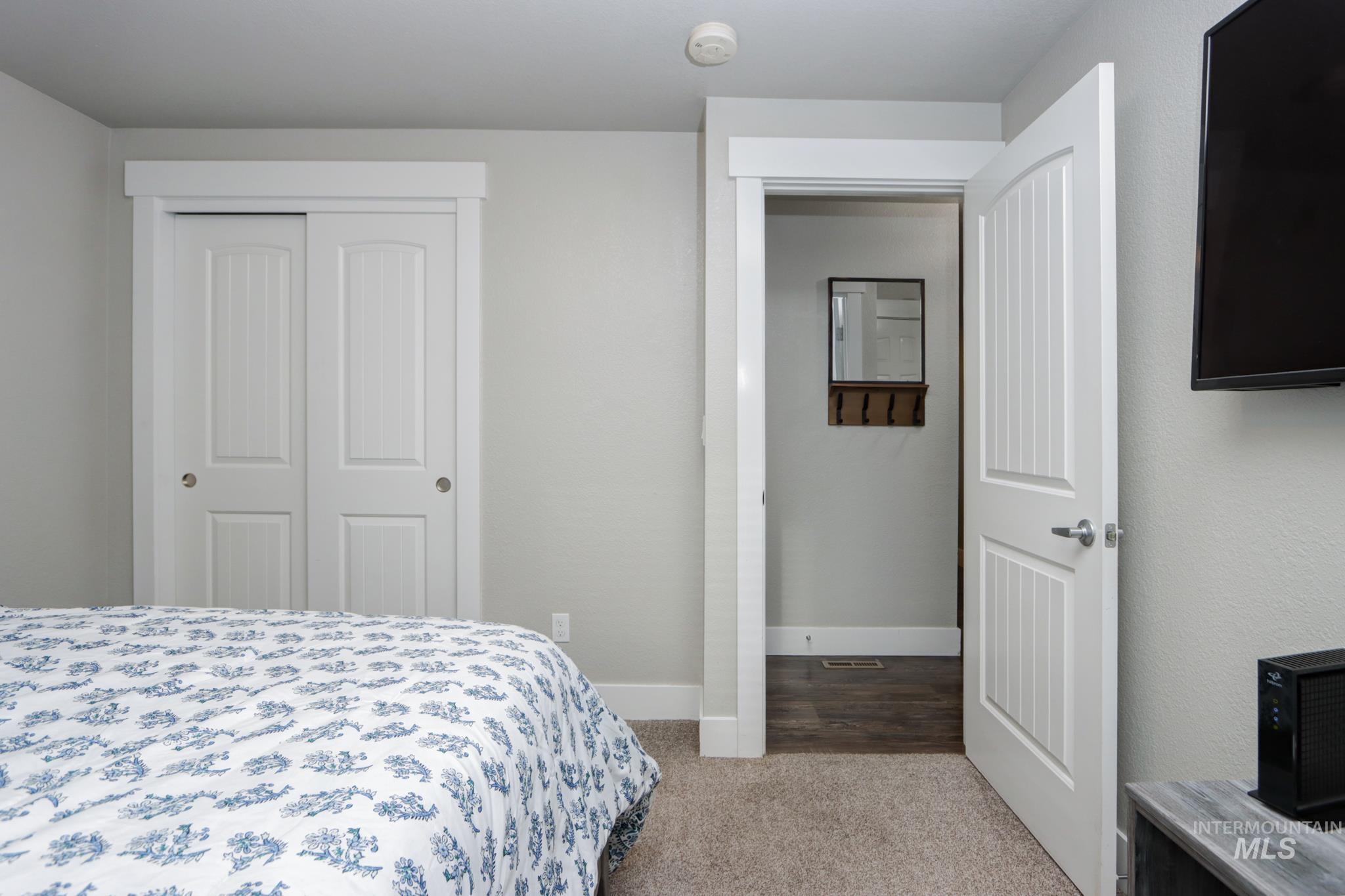 Bedroom with light carpet and a closet