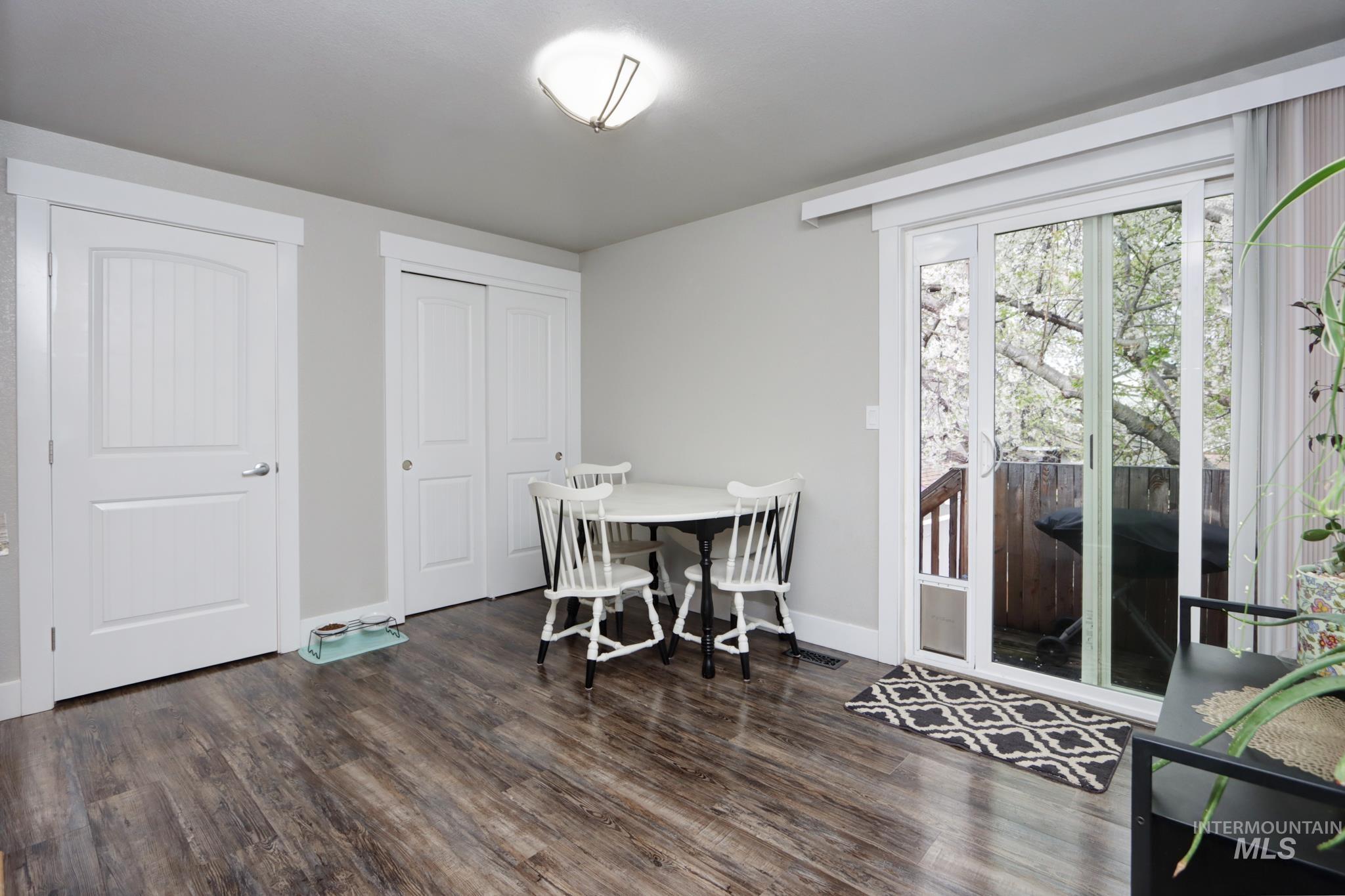 Dining space featuring dark wood-style flooring and baseboards